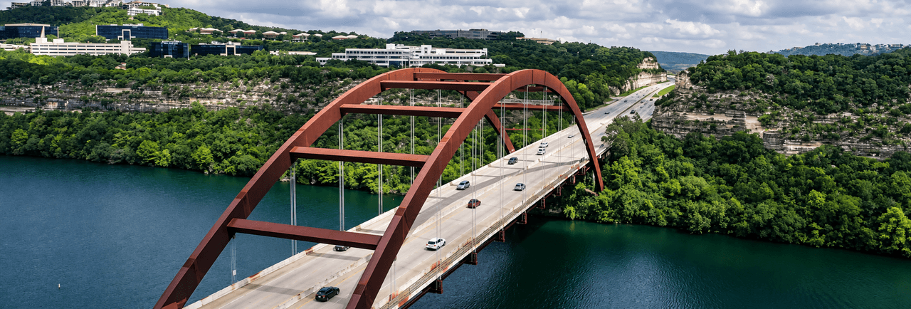 Aerial view of the Pennybacker Bridge over Lake Austin, near the Cedar Park and Kingsland, TX communities served by Grissom Insurance Group